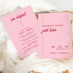 two pink cards sitting on top of a white blanket