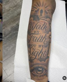 a man's arm with an eye and words on it that says work by faith not by sight