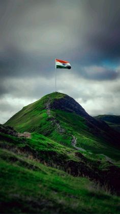 a flag on top of a green hill