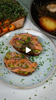 two sandwiches are on a plate next to some vegetables and other food items in bowls