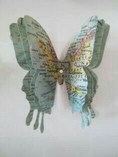 a butterfly made out of maps is hanging on the wall