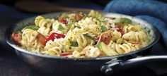 a bowl filled with pasta and vegetables on top of a table