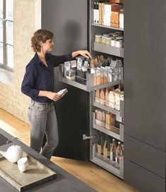 a woman standing in front of a pull out spice rack