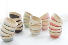 a group of wooden bowls sitting next to each other on a white counter top in front of a window