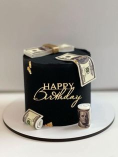 a birthday cake with money on it and the words happy birthday written in gold lettering