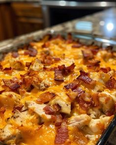 a casserole dish with chicken, bacon and cheese