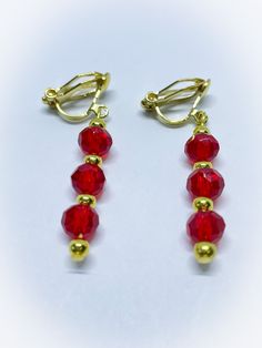 These are a lovely pair of Red Triple Crystal Faceted Crystal Dangle Dropper Clip On Earrings for  non pierced ears. They feature gorgeous 6mm briolette faceted crystal beads in red. They are interspersed with gold colour metal round beads  These handmade earrings are on gold colour clip ons  and are suitable for people with non pierced ears and are 1 inch in length with a drop of 1.75 inches.  To view more JulieDeeleyJewellery handmade jewellery please click this link : www.etsy.com/shop/JulieDeeleyJewellery JULIE DEELEY JEWELLERY SOCIAL MEDIA LINKS Follow me on Facebook: www.facebook.com/juliedeeleyjewellery Follow me on Twitter: twitter.com/julie_deeley Follow me on Pinterest: pinterest.com/juliedeeley Follow me on Instagram: http://instagram.com/juliedeeley Elegant Red Single Clip-on Earring, Red Drop Clip-on Earrings As Gift, Red Drop Clip-on Earrings For Gift, Red Dangle Clip-on Earring, Red Dangle Single Clip-on Earring, Red Clip-on Dangle Jewelry, Red Clip-on Earrings As Gift, Red Clip-on Earrings For Party, Elegant Red Dangle Clip-on Earrings