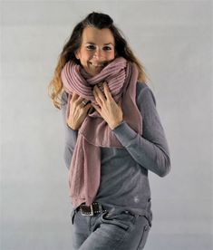 a woman is smiling while wearing a scarf