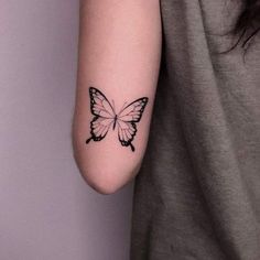 a woman's arm with a butterfly tattoo on the left side of her arm