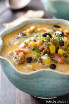 a blue bowl filled with soup on top of a wooden table