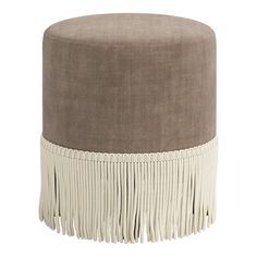 a round ottoman with tassels and fringe trim