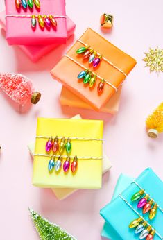 four colorful boxes are sitting next to each other on a white surface with decorations around them