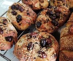 bread rolls with olives and sesame seeds on a cooling rack