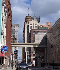 a car driving down a street next to tall buildings