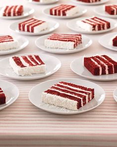 several slices of red velvet cake on white plates with pink and white striped tablecloth