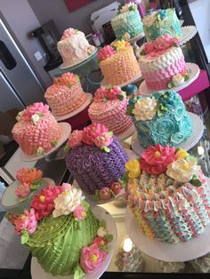 there are many different cakes on the table and one is decorated with fondant flowers