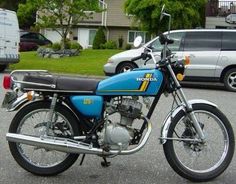 a blue and black motorcycle parked in a parking lot