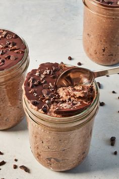 two jars filled with chocolate pudding on top of a table