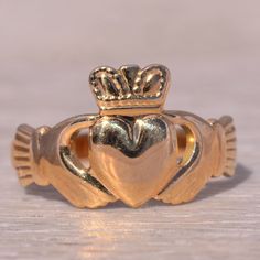 This Stunning Piece, Known As The Irish Claddagh, Is A Beautifully Crafted Claddagh Ring Signed By Solvar. The Ring Showcases The Traditional Claddagh Design, Featuring Two Hands Holding A Heart Topped With A Crown, Symbolizing Love, Loyalty, And Friendship. This Ring Is Crafted In 14 Karat Yellow Gold, Adding A Classic And Elegant Touch To Its Symbolic Design. This Exquisite Ring Is Currently A Finger Size 8 Yet Can Be Adjusted To Any Finger Size For An Additional Charge Upon Request, Ensuring A Perfect Fit. Claggagh Ring, Hands Holding A Heart, Two Hands Holding, Holding A Heart, Irish Claddagh, Claddagh Ring, Hands Holding, Claddagh Rings, Heart Top