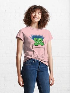 a woman wearing a pink t - shirt with a green monster in the pocket