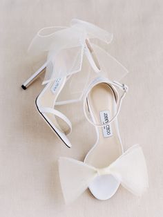 the bride's shoes are all white and they have bows on them for decoration