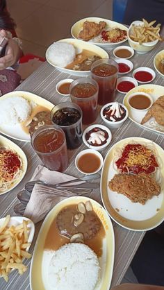 a table topped with plates and bowls filled with different types of food next to drinks