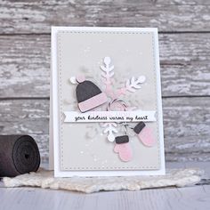 a handmade card with snowflakes and mittens on it, next to a roll of felt