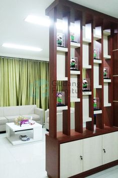 a living room filled with white furniture and lots of bookshelves on top of wooden shelves