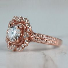 a rose gold engagement ring with an oval cut diamond surrounded by small white and clear diamonds