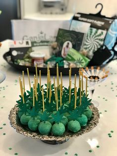 there are many green candies in the bowl with sticks sticking out of it and on top of each other