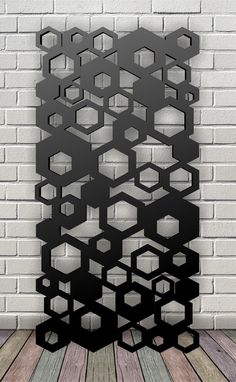 an abstract black and white photo with hexagonal shapes on it, against a brick wall