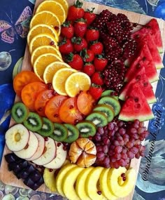 a wooden cutting board topped with lots of fruit