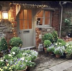 an image of a house that is decorated with flowers and potted plants on the front porch