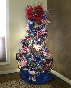 a decorated christmas tree with red, white and blue decorations on the top is shown