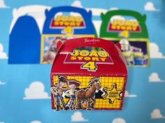 three toy story boxes sitting on top of a blue and white tablecloth covered wall