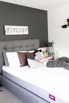 a man laying on top of a bed in a bedroom