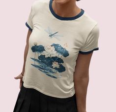 Add a touch of vintage flair to your wardrobe with our cotton ringer tee, featuring a tranquil image of a dragonfly & lotus flowers. Crafted from soft, premium cotton, this tee combines vintage style with a tranquil design. The contrasting ribbed collar and sleeves offer a classic ringer look, perfect for any casual occasion. Made from 100% ring spun cotton. Sizing is Unisex, if you typically purchase women's sizes, please refer to the measurements in the item photos and consider sizing down. Aesthetic Graphic Print Tops For Summer, Vintage Tops With Front Print For Spring, Aesthetic Graphic Print Tops For Spring, Spring Aesthetic Graphic Print T-shirt, Vintage Printed Spring T-shirt, Vintage Summer Tops With Front Print, Spring Aesthetic Graphic T-shirt, Spring Vintage T-shirt With Vintage Print, Dragonfly Shirt