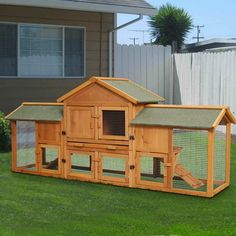 a large wooden chicken coop in the grass