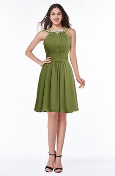 a woman in a green dress posing for the camera with her hands on her hips