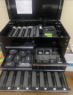 an open tool box filled with tools on top of a table