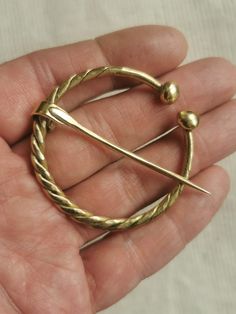 Large Fibula of brass Twisted Fibula Horseshoe shapes Brooch Scarf Cloak pin Replic Viking Jewelry Historical Reenactment Pin GIFT Lenght 55mm.  2.2 inches Width   55mm.  2.2 inches Brooch made of raw 5mm. brass wire, hand hammered and forged. Made to order just for you An archaeological founding of Eastern Europe inspires this handcraft. Brooches similar to this were very common in the medieval period. Pinning method: insert the needle into the fabric, set the aperture on the needle, and then r Fibula Brooch, Brooch Scarf, Cloak Pin, Medieval Cloak, Historical Reenactment, Fabric Set, Medieval Period, Viking Jewelry, Medieval Fantasy