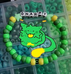 the beads are green and yellow with an image of a dragon on it's face