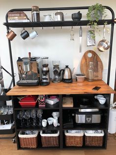 a kitchen area with pots and pans on the shelf, coffee pot rack, utensils and other items