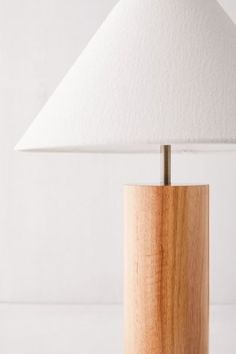 a wooden table lamp with a white shade