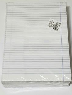 a piece of lined paper sitting on top of a white table