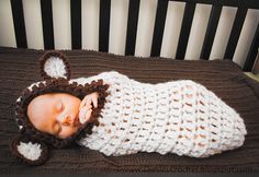 a baby sleeping in a crocheted bear outfit