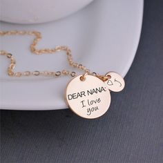 "A 3/4 inch 14k gold filled disc is engraved with the words \"DEAR NANA: I love you\" and is hanging from a 14k gold filled chain. Also available in 14k rose gold filled and sterling silver filled chain with stainless steel engraved disc. **CHARMS: ALL initial charms or birthstone charms are optional. Necklace includes the Dear Nana pendant. Select the total of additional charms from the drop down and then let me know the initials or birthstones in the text box** Let me know if you have any ques Bridgets Cross, Brigids Cross, Nana Christmas, Nana Jewelry, Nana Necklace, Diamond Bar Necklace, Diy Gifts For Mom, Lotus Necklace, Wiccan Jewelry