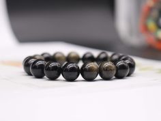 Material:Golded Obsidian Beads Size:4mm-12mm Bracelet length: 6 inch to 9 inch Quality:AAA Quantity：1 bracelet How to measure the bracelet size,there are two ways as below showed for your reference 1.Make a circle around the wrist with the soft ruler, the length of the circle is the circumference of your hand, no need to reserve space. 2.Wrap your wrist with a note or cotton thread, then mark it with a pen, and measure with a ruler. How do we packed the bracelet when shipped out 1.Each bracelet Gift Bracelet, Tourmaline Beads, 15 May, Rainbow Fluorite, Organza Gift Bags, Gorgeous Bracelet, How To Measure, Beading Supplies, Bracelet Length