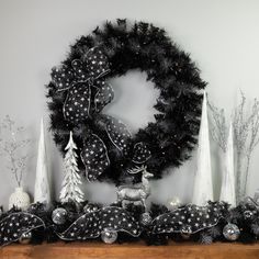 a christmas wreath and other decorations on a mantel