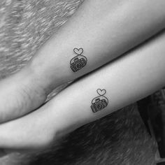 two people with tattoos on their arms holding each other's hands